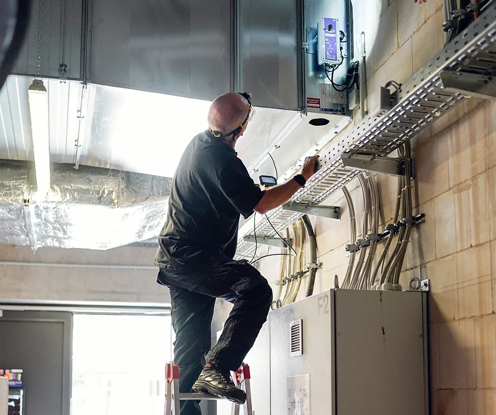 Techniker von S&H bei der Wartung einer Brandschutzklappe an einer Lüftungsanlage in Göttingen